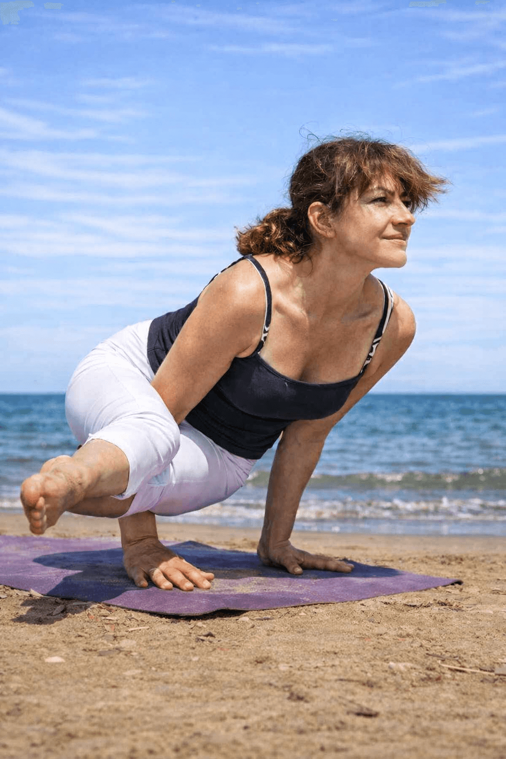 Tina Mastandrea in pratica yoga su una spiaggia